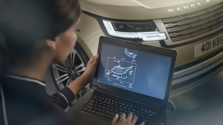 Lady looking at computer with a spec of a car